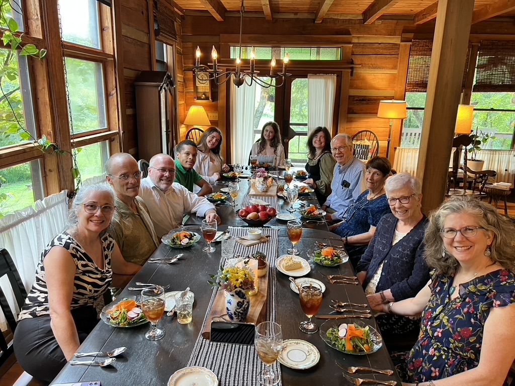 Guests gathered around a long dinner table in the Farmhouse at Snug Hollow Farm
