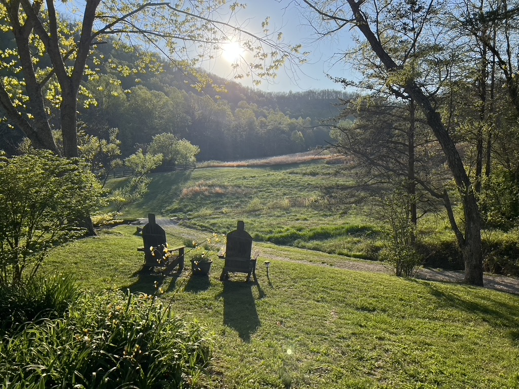 Two Adirondack chairs overlooking the valley at sunrise at Snug Hollow Farm